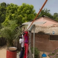 Village de Bouhinor, Casamance, Sénégal. La maison de Paul Mendy. Inspection d'un panneau photovoltaïque.